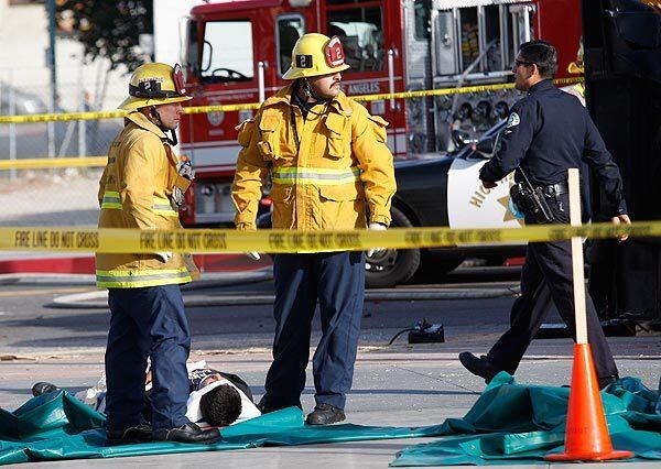 Firefighters wait to transport an injured student who was taken off the bus.