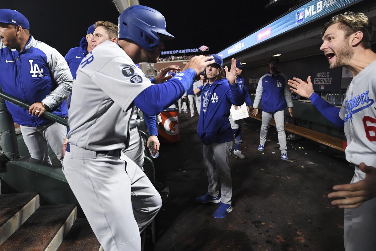 Cody Bellinger celebrates with Dodgers teammate Trea Turner in the dugout.