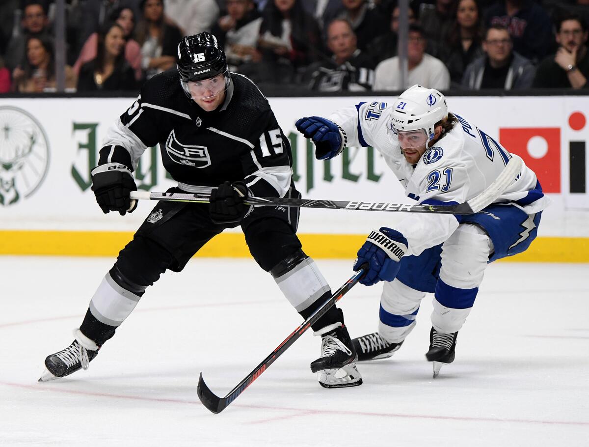 Kings' Ben Hutton (15) watches his shot in front of Tampa Bay Lightning's Brayden Point (21) during the second period at Staples Center on Wednesday.