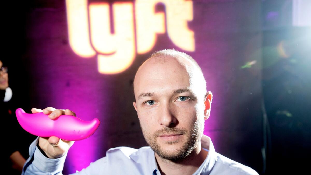 Logan Green, co-founder and chief executive officer of Lyft, displays his company's "glowstache" during a launch event in San Francisco on Jan. 26, 2015.