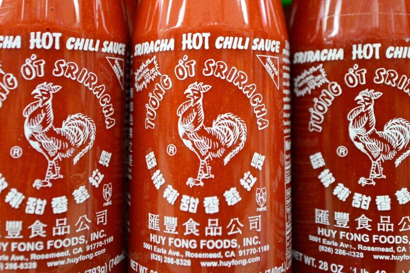 Bottles of Sriracha chili sauce on shelves inside a supermarket in Rosemead.
