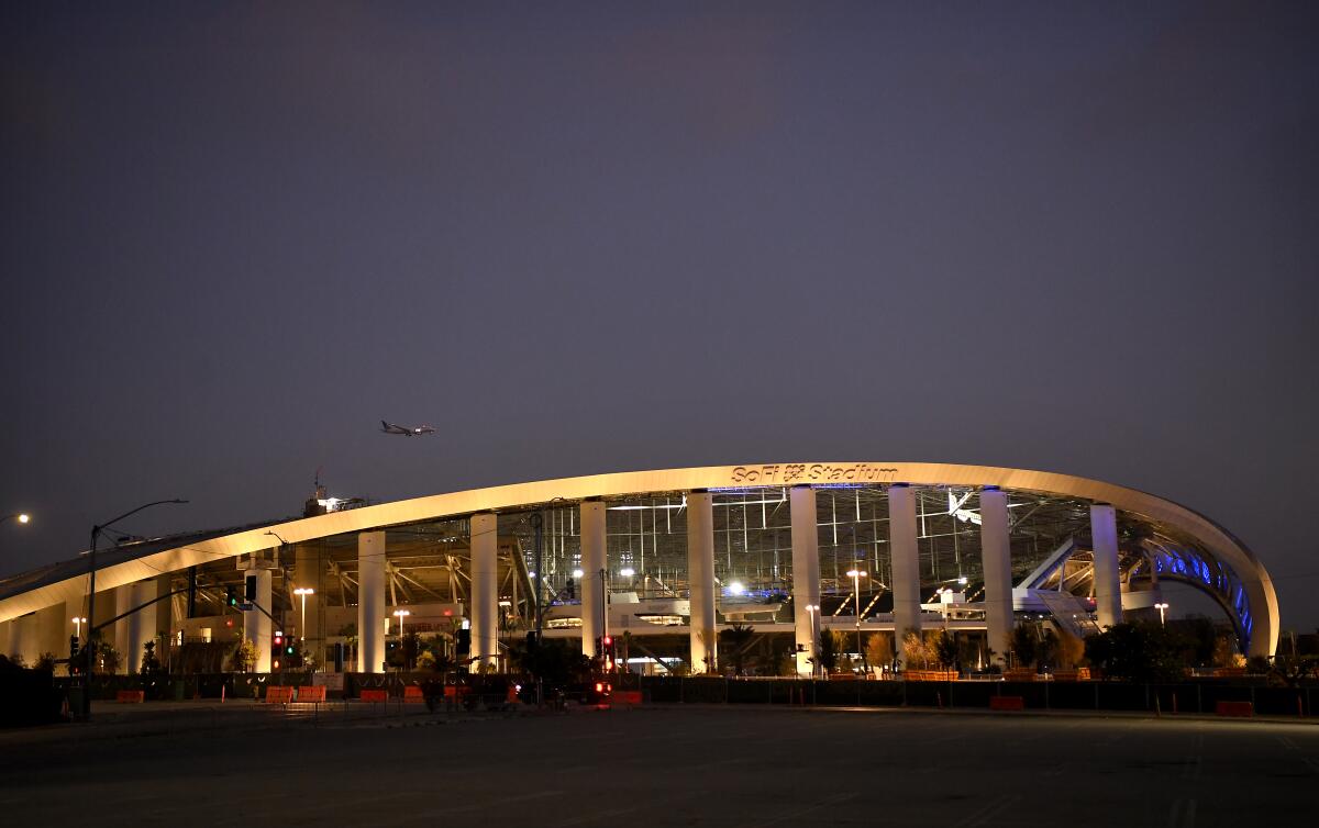 A view of SoFi Stadiums' curving roofline at dusk