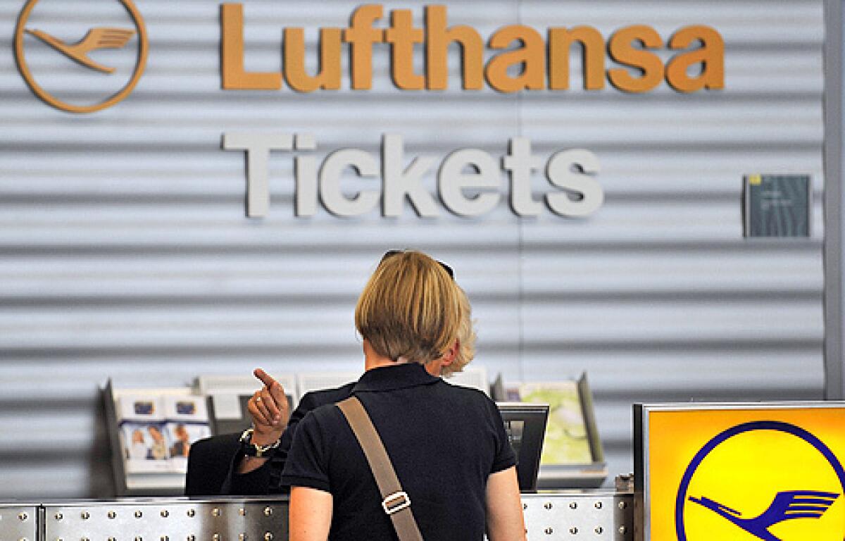 A woman talks at a Lufthansa counter at the airport in Duesseldorf, Germany, Friday, July 25.