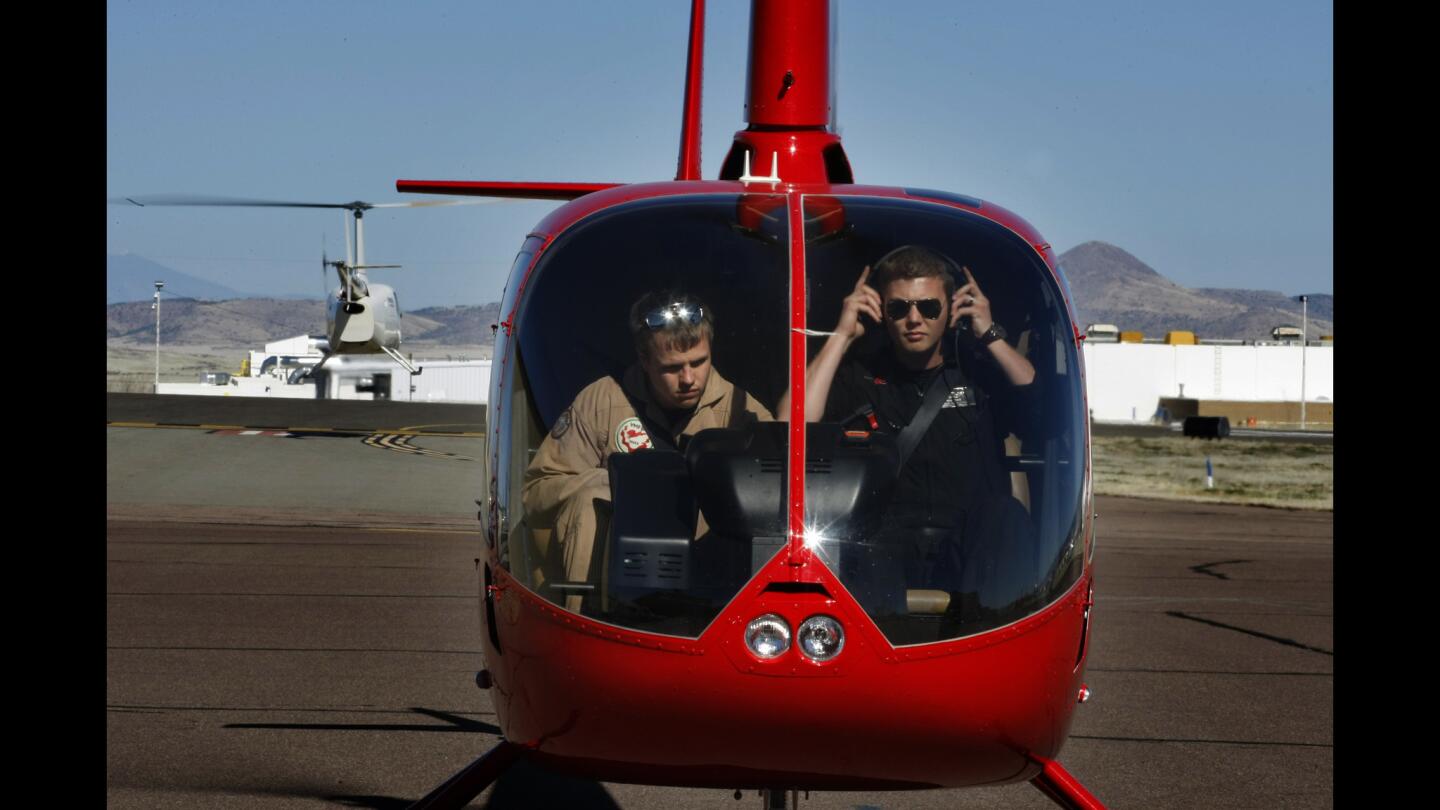 Yavapai Community College flight student Sam Mills, left, and Universal Aviation flight instructor Ben Lewis prepare for a commercial training flight in an R-66 helicopter from Prescott Municipal Airport in Arizona. The company's 18-month pilot training course is linked to the college.
