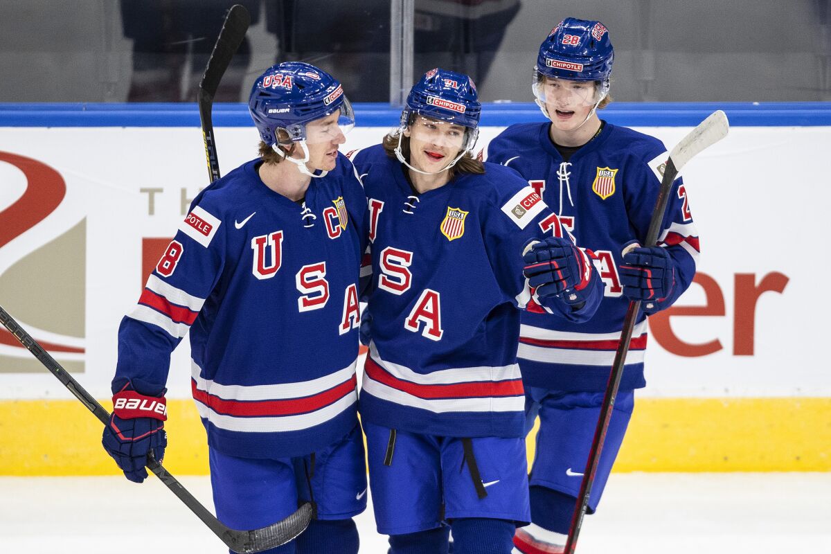 FILE - United States' Jake Sanderson, from left, Tanner Dickinson and Chaz Lucius celebrate a goal against Finland during the first period of an exhibition game in Edmonton, Alberta, Dec. 23, 2021, before the IIHF World Junior Hockey Championship tournament. Sanderson, who plays hockey for the University of North Dakota, was named to the 2022 U.S. Olympic team after the NHL announced it was not sending players to the Olympics. (Jason Franson/The Canadian Press via AP, File)