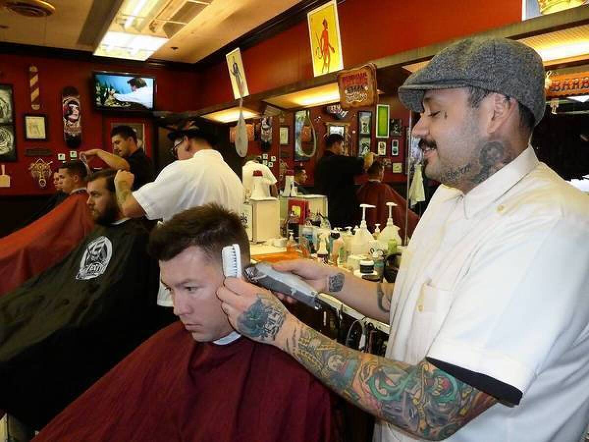 Martin Corona, right, with customer Casey Ziegert at his Hi-Rollers barbershop near downtown Las Vegas. Corona's specialty: the rockabilly cut.