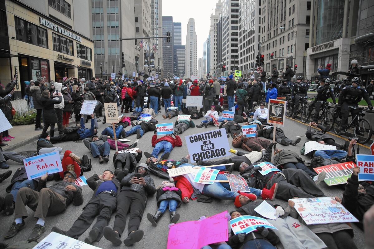 Demonstrators hold a "die-in" on North Michigan Avenue in Chicago. The "Black Christmas" demonstration on Thursday, organizers said, was held to protest the killing of Laquan McDonald, a black teen shot 16 times by Chicago police last year.