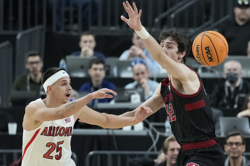Arizona's Kerr Kriisa (25) passes around Stanford's Maxime Raynaud (42) during the first half of an NCAA college basketball game in the quarterfinal round of the Pac-12 tournament Thursday, March 10, 2022, in Las Vegas. (AP Photo/John Locher)