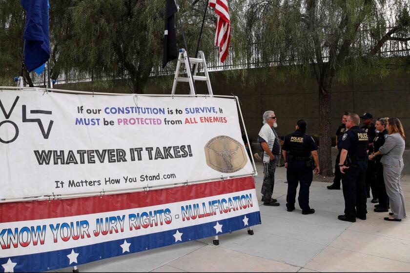 Federal police officers speak with Bundy supporters outside of the federal courthouse, Monday, Oct. 30, 2017, in Las Vegas. Jury selection is set to begin in Las Vegas for the long-awaited trial of Nevada cattleman and states' rights figure Cliven Bundy, two sons and one other co-defendant on charges stemming from an armed standoff with federal agents in April 2014. (AP Photo/John Locher)