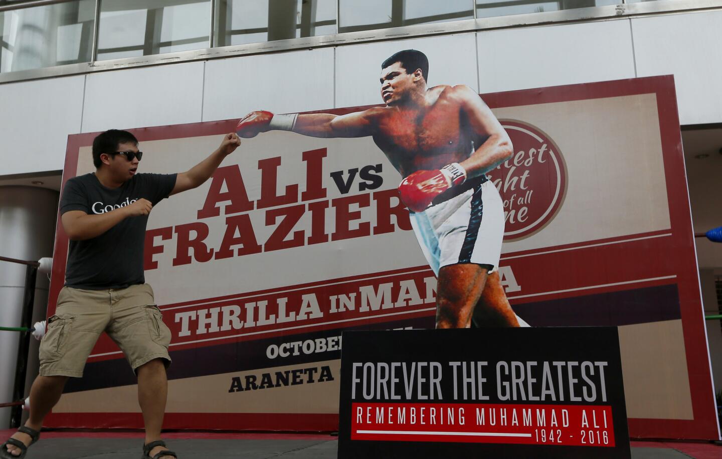 Romy Doria poses before a standee of Muhammad Ali during the launch of an exhibit of photos and memorabilia from the "Thrilla in Manila" World Heavyweight boxing fight between Muhammad Ali and Joe Frazier at The Ali Mall and the Smart Araneta Coliseum in suburban Quezon city northeast of Manila, Philippines on June 10, 2016.