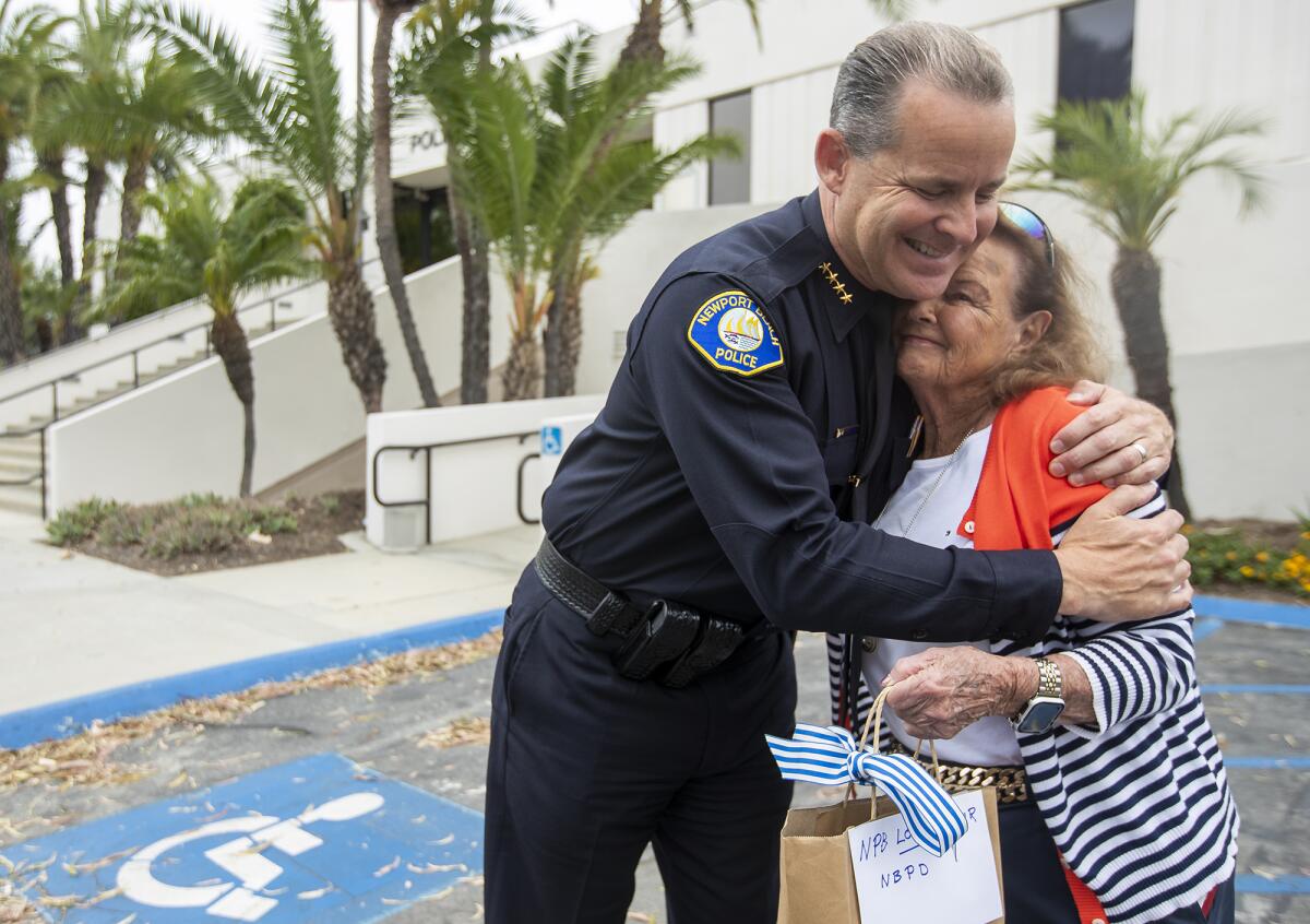 Dotty McDonald, 91, gets a hug from Newport Beach Police Department Chief Jon Lewis after giving gift cards for officers. 