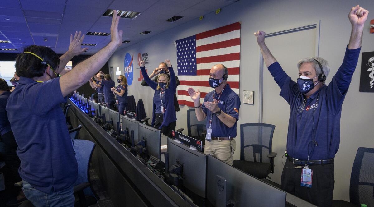 Members of NASA's Mars 2020 team at JPL react after the Perseverance rover touched down on Mars.