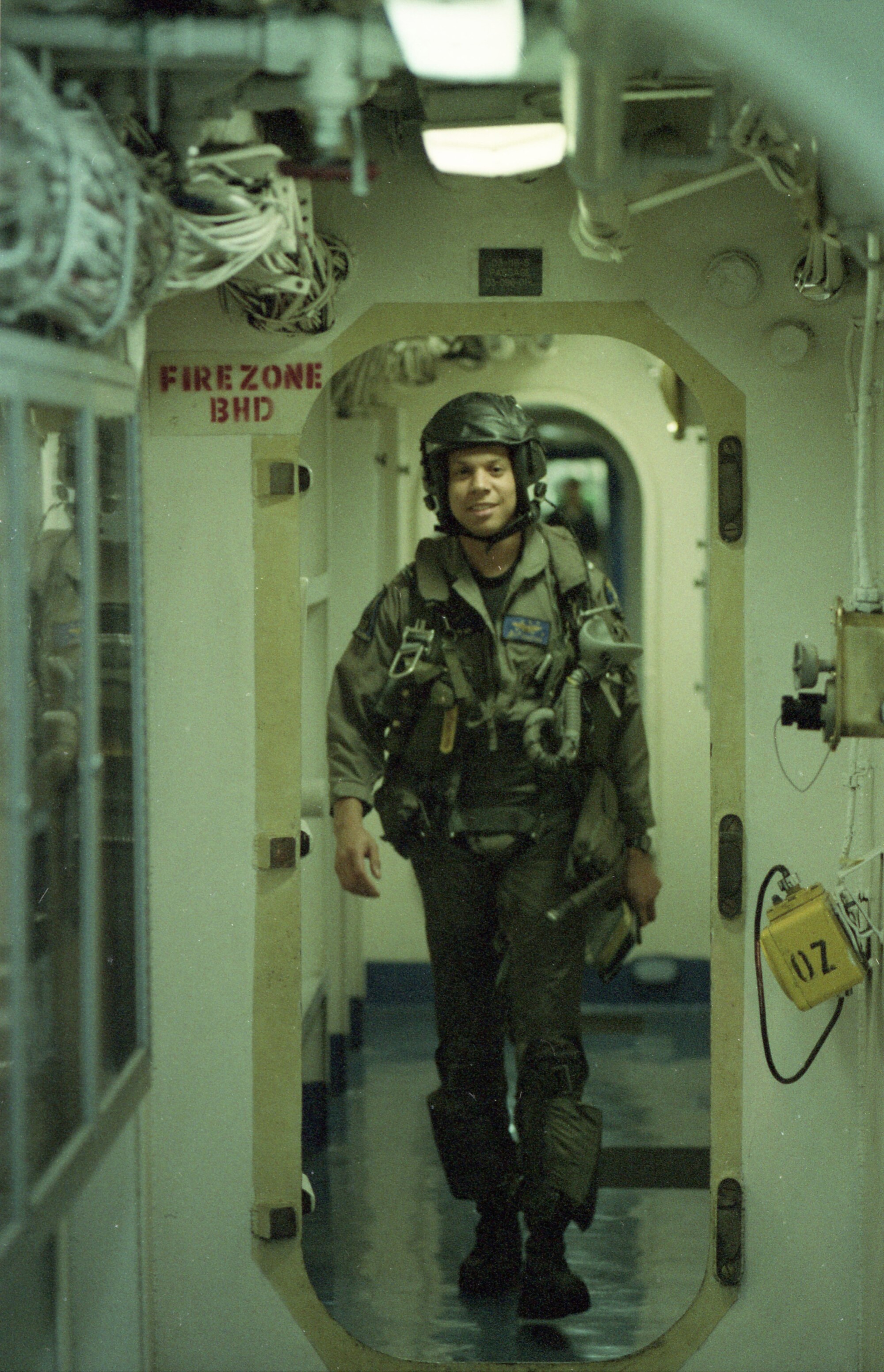 An aviator walks along a passageway of the aircraft carrier Kitty Hawk 