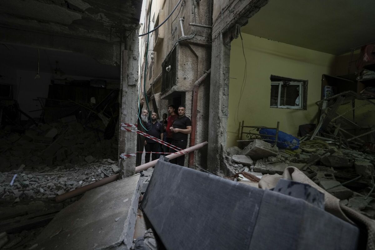 Palestinians inspect a damaged building following an Israeli army raid in the Balata refugee camp near the West Bank town of Nablus Monday, May 22, 2023. Palestinian health officials say Israeli fire has killed at least three people in a West Bank refugee camp. (AP Photo/Majdi Mohammed)
