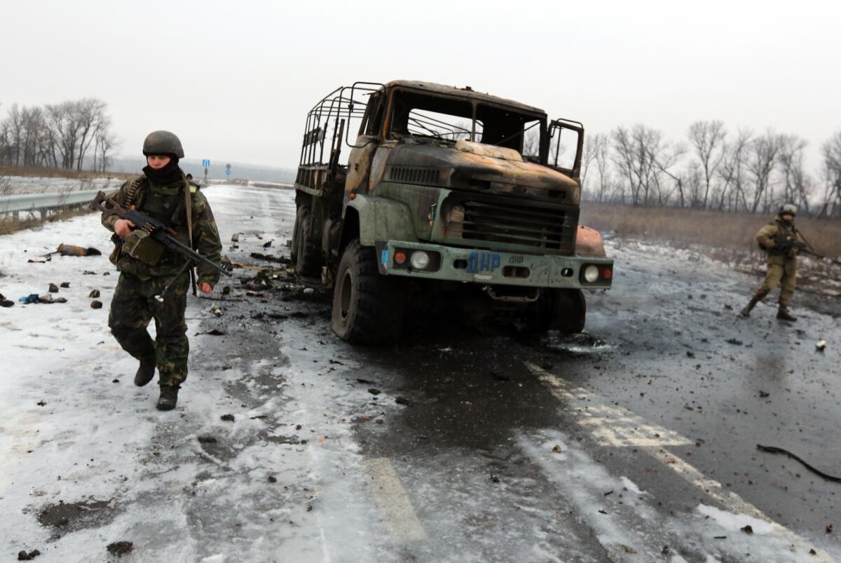 Ukrainian soldiers walk by a destroyed truck of pro-Russia separatist forces near the Donetsk airport on Jan. 23.