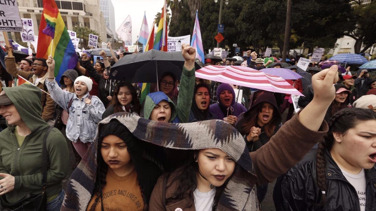 Marchers carry umbrellas Sunday during the International Women's Day event in downtown Los Angeles.