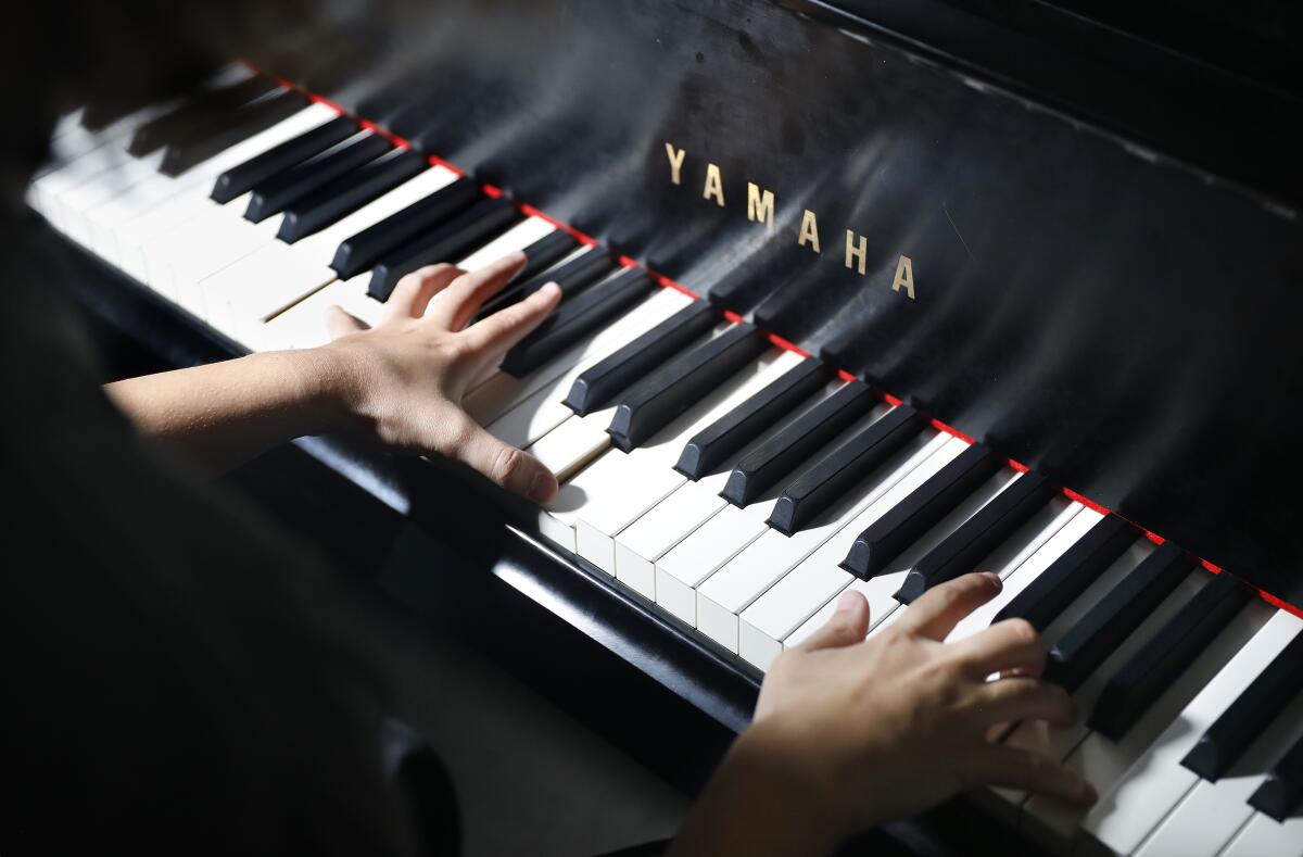 A close-up of Brielle "Yuuki" Lubin's hands at a Yamaha piano keyboard.
