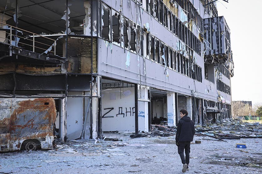 A resident passes a damaged building in Mariupol, Ukraine, in an area controlled by the Donetsk People's Republic.