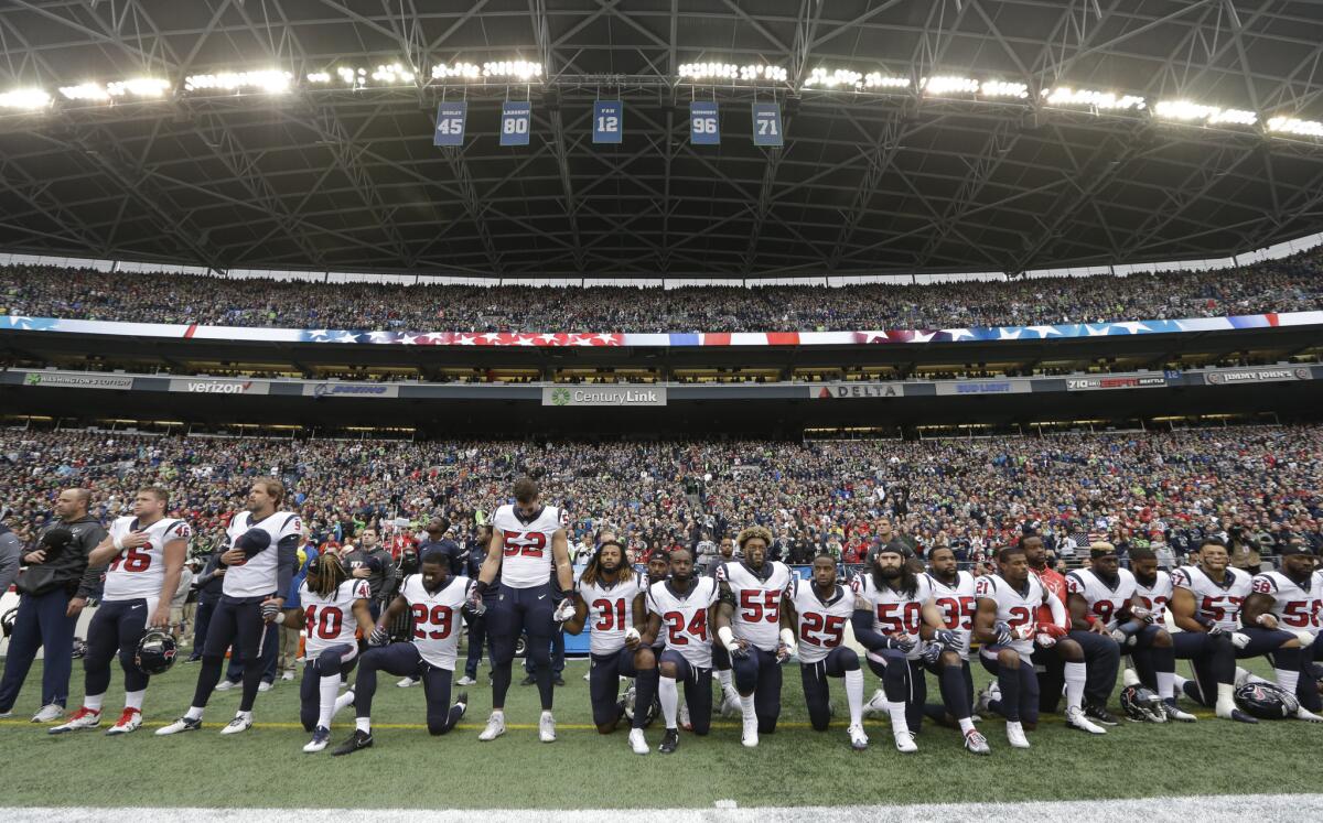 ARCHIVO - En esta foto del 29 de octubre de 2017, jugadores de los Texans de Houston se hincan durante el himno nacional previo a un partido de la NFL ante los Seahawks de Seattle. (AP Foto/Elaine Thompson)