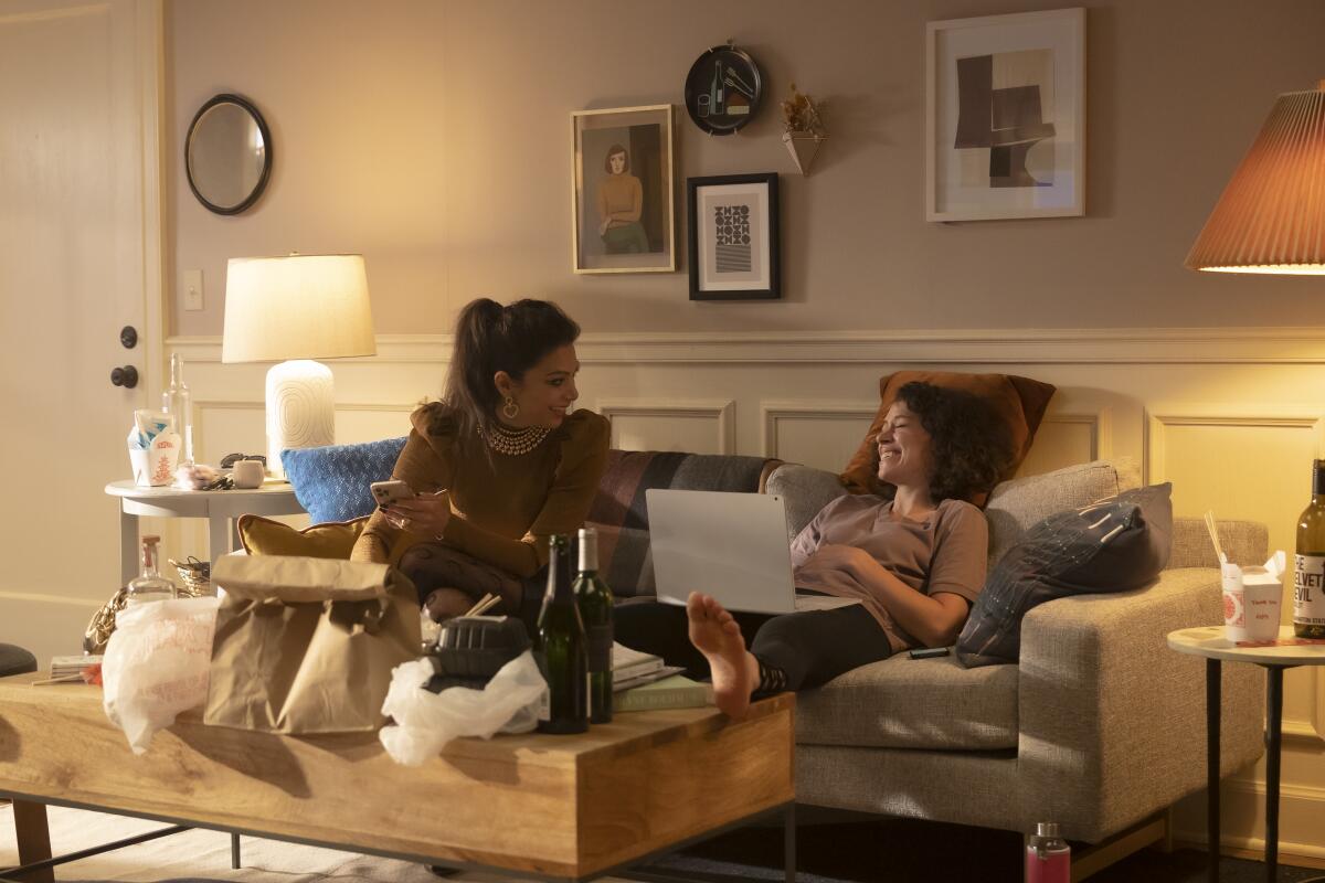 two women sitting on a couch surrounded by takeout and alcohol