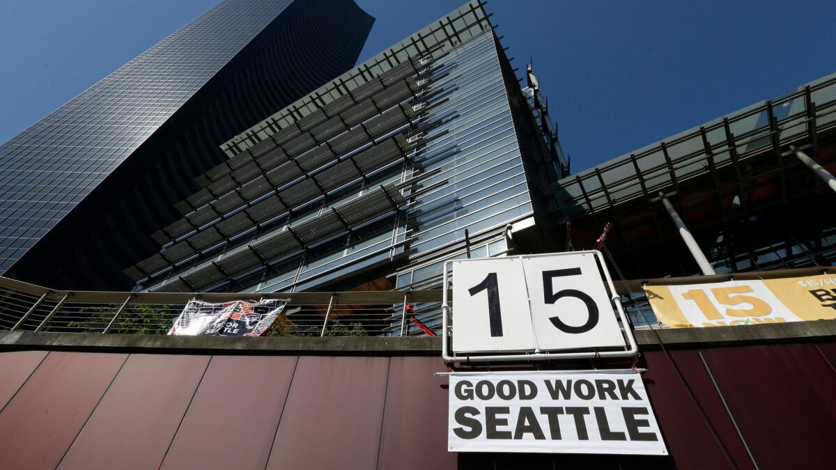 A sign that reads "15 Good Work Seattle" is displayed below Seattle City Hall after the City Council passed a $15 minimum wage measure in 2014.