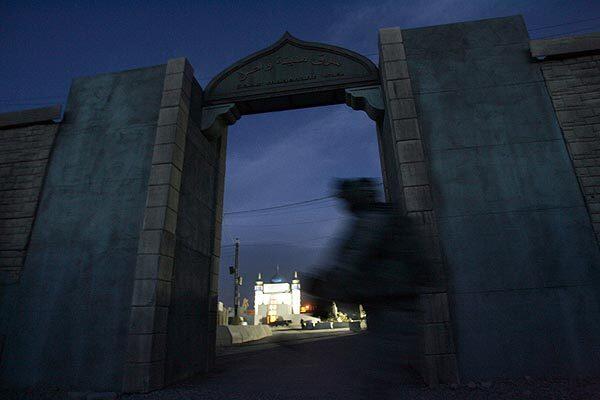 A soldier glides past an arched gateway at Medina Wasl with the city mosque in the background. The village, assembled at the National Training Center at Ft. Irwin in the Mojave Desert, is used to prepare U.S. troops for duty in Iraq.