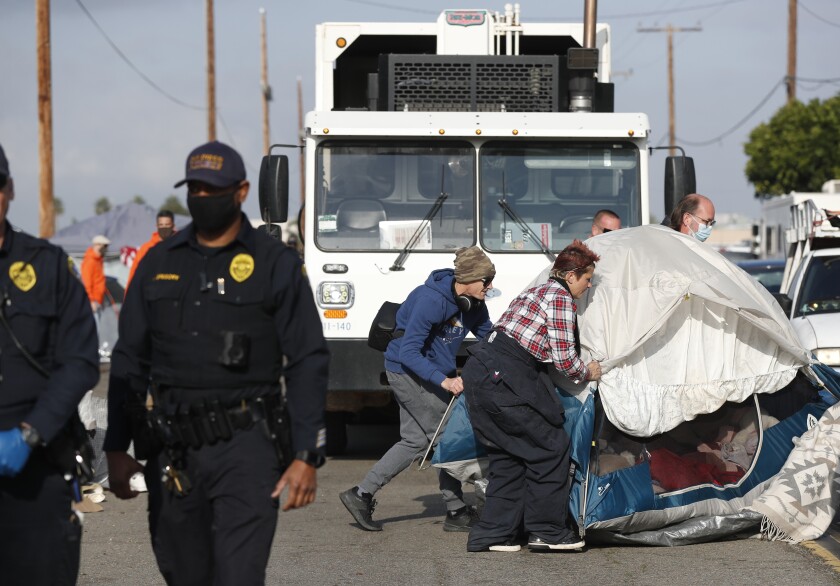 Ali Russ gets help moving her belongings as workers the city of San Diego removes a homeless encampment on Sports Arena Blvd