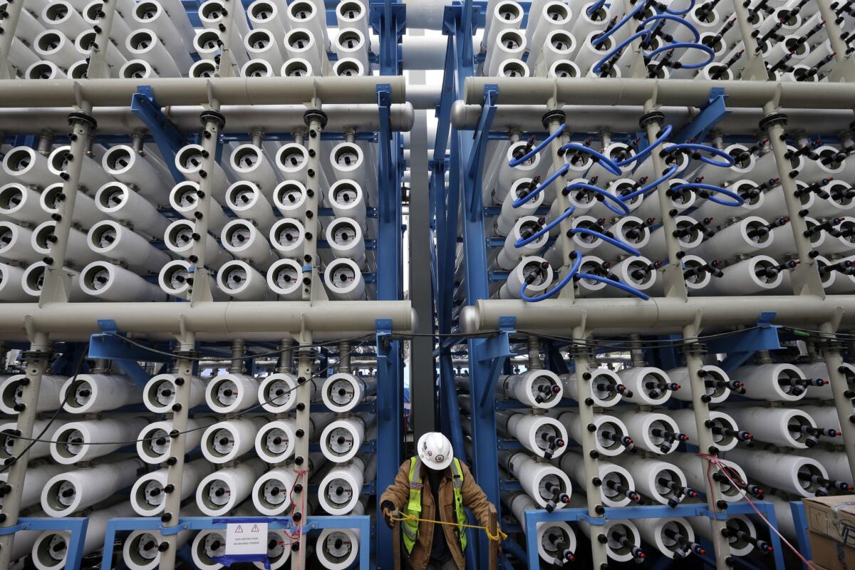 A worker climbs stairs among some of the 2,000 pressure vessels that will convert sea water into fresh water through reverse osmosis when the plant opens in Carlsbad. The $1-billion project is meant to provide 50 million gallons of drinking water daily.