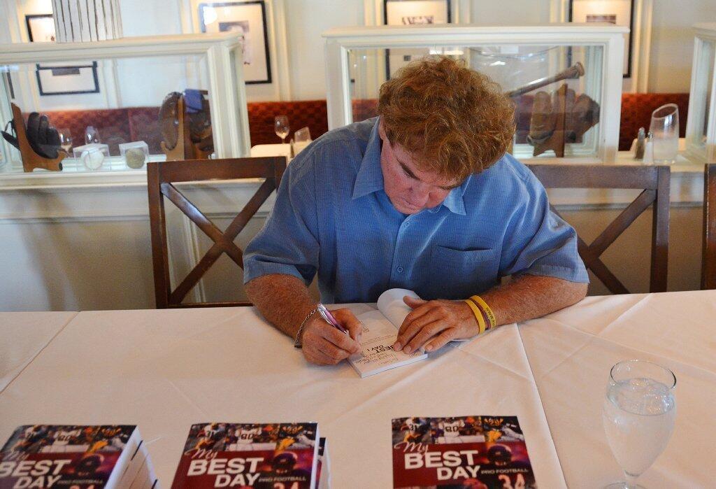 Mark Keys signs one of his My Best Day books during his book signing at The Cannery Restaurant on Saturday.