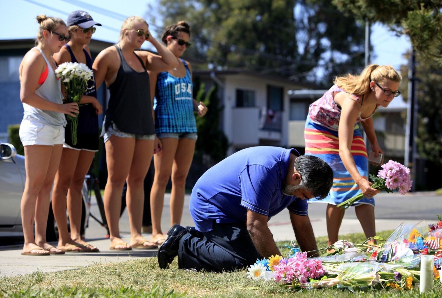 Jose Cardoso, 50, cries and prays next to flowers in front of the Alpha Phi sorority house, which was targeted in the rampage. He said he has a local printing shop and has done a lot of work for the fraternities and sororities. He said he thinks of the students as his own children.