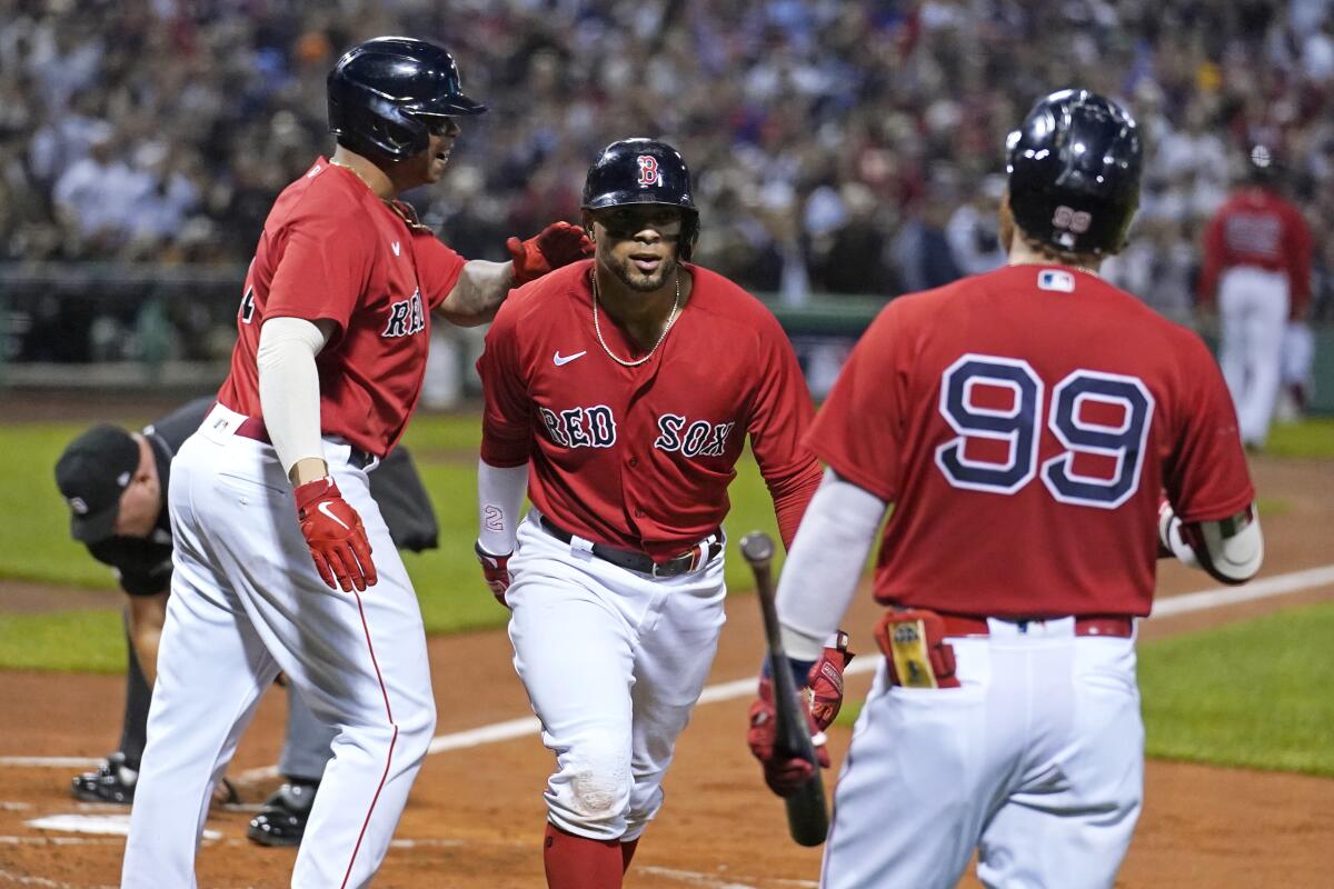 Boston Red Sox's Xander Bogaerts celebrates his two-run homer with Rafael Devers and Alex Verdugo.