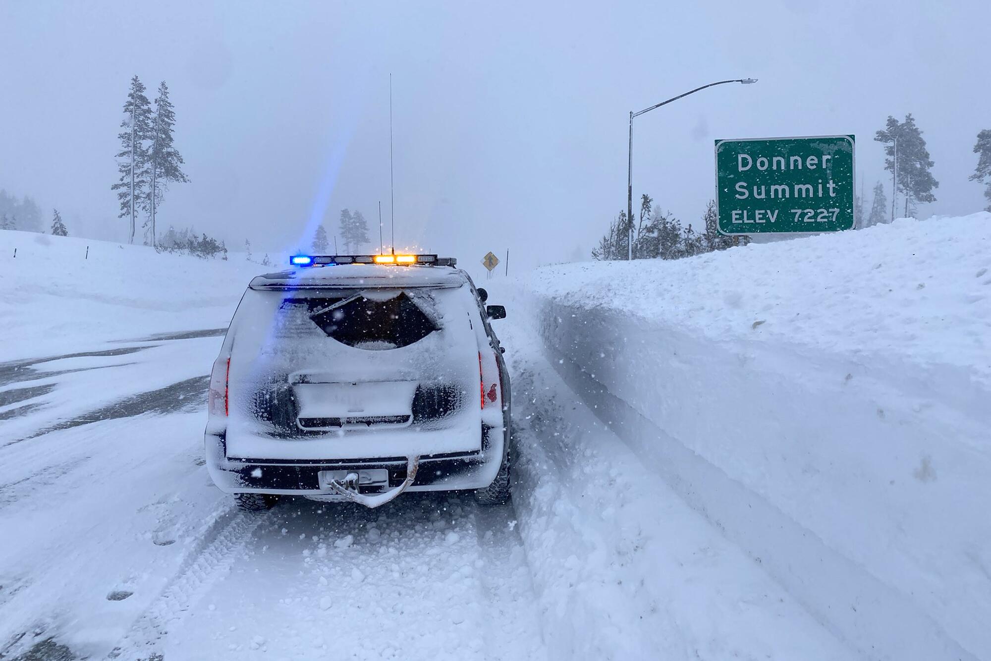 A California Highway Patrol vehicle drives through snow