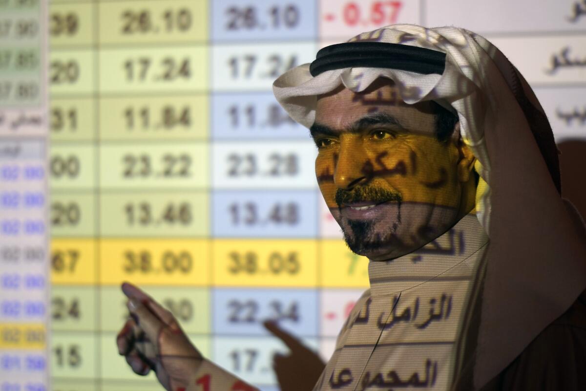 A Saudi trader stands in front of a screen displaying the Saudi stock market Dec. 12 at the Arab National Bank in Riyadh.