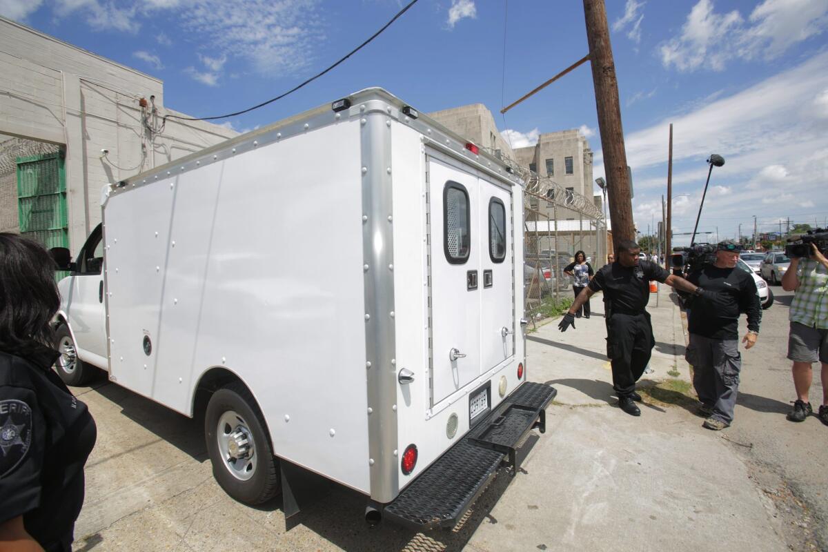 Orleans Parish sheriff's deputies hold back the media as a van carrying accused Robert Durst leaves court Thursday.