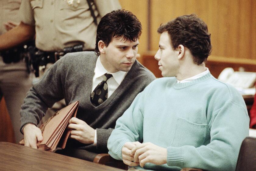 Lyle Menendez, left confers with brother Erik during a court appearance, April 2, 1991 in Beverly Hills, California. Lawyers for the brothers won another delay of a preliminary hearing while they seek a state Supreme Court opinion on whether an alleged murder confession is protected by doctor-patient privilege. (AP Photo/Kevork Djansezian)