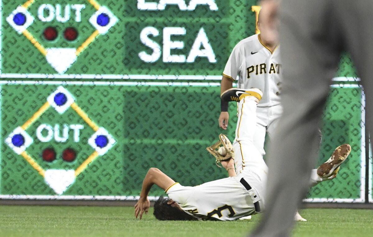 Pittsburgh Pirates' Cole Tucker (3) makes a diving catch for an out in the seventh inning against the Cincinnati Reds during a baseball game in Pittsburgh, Friday, Oct. 1, 2021. (AP Photo/Philip G. Pavely)