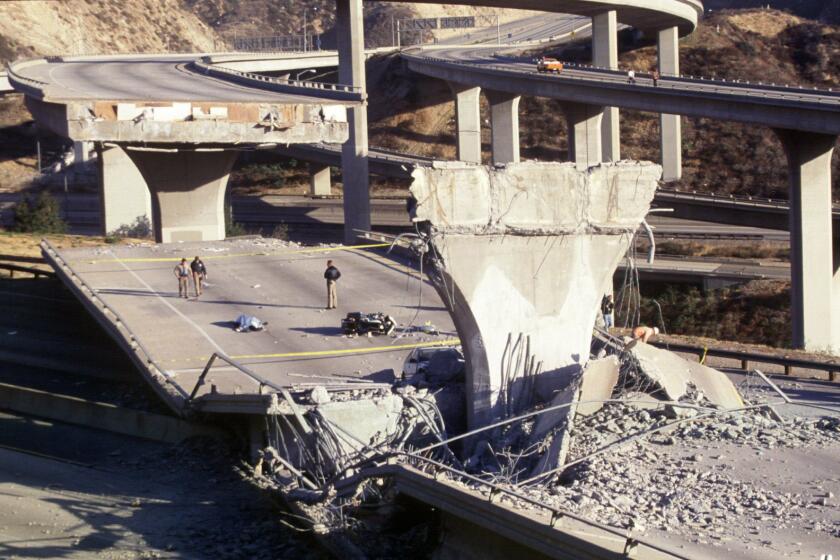 Overview of the damage at the I-5 and 14 freeway interchange. Motorcycle officer's body on fallen section of freeway.