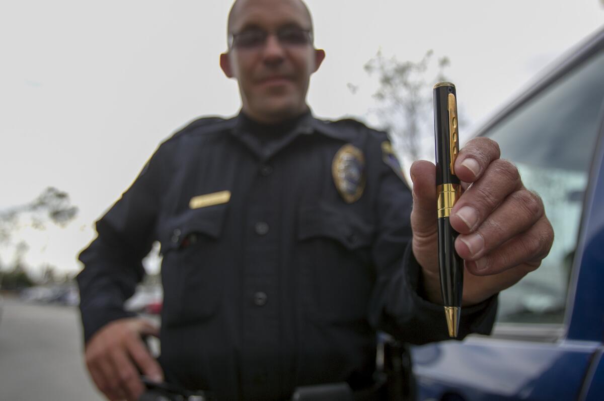 Tom Arensdorf, a public safety officer with Orange Coast College, shows off the department's pen cameras to record what happens while they're on duty.