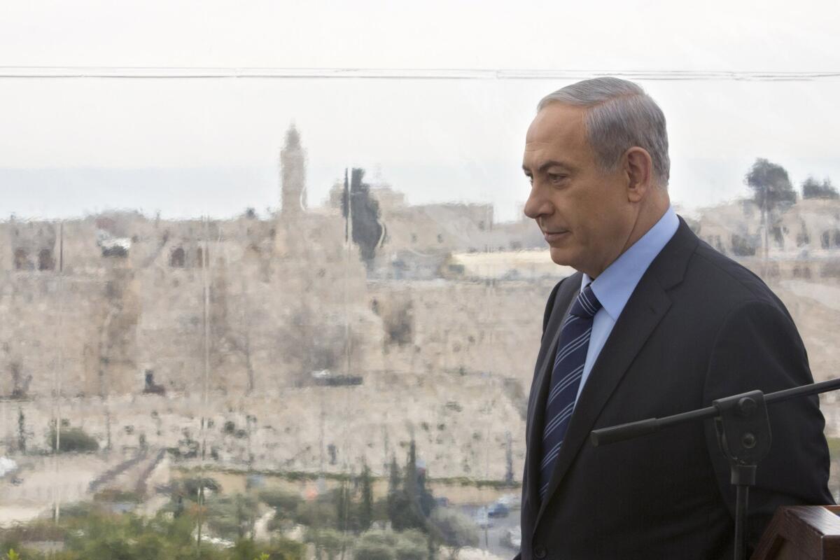 Israeli Prime Minister Benjamin Netanyahu walks past a window overlooking the Old City of Jerusalem on Feb. 23.
