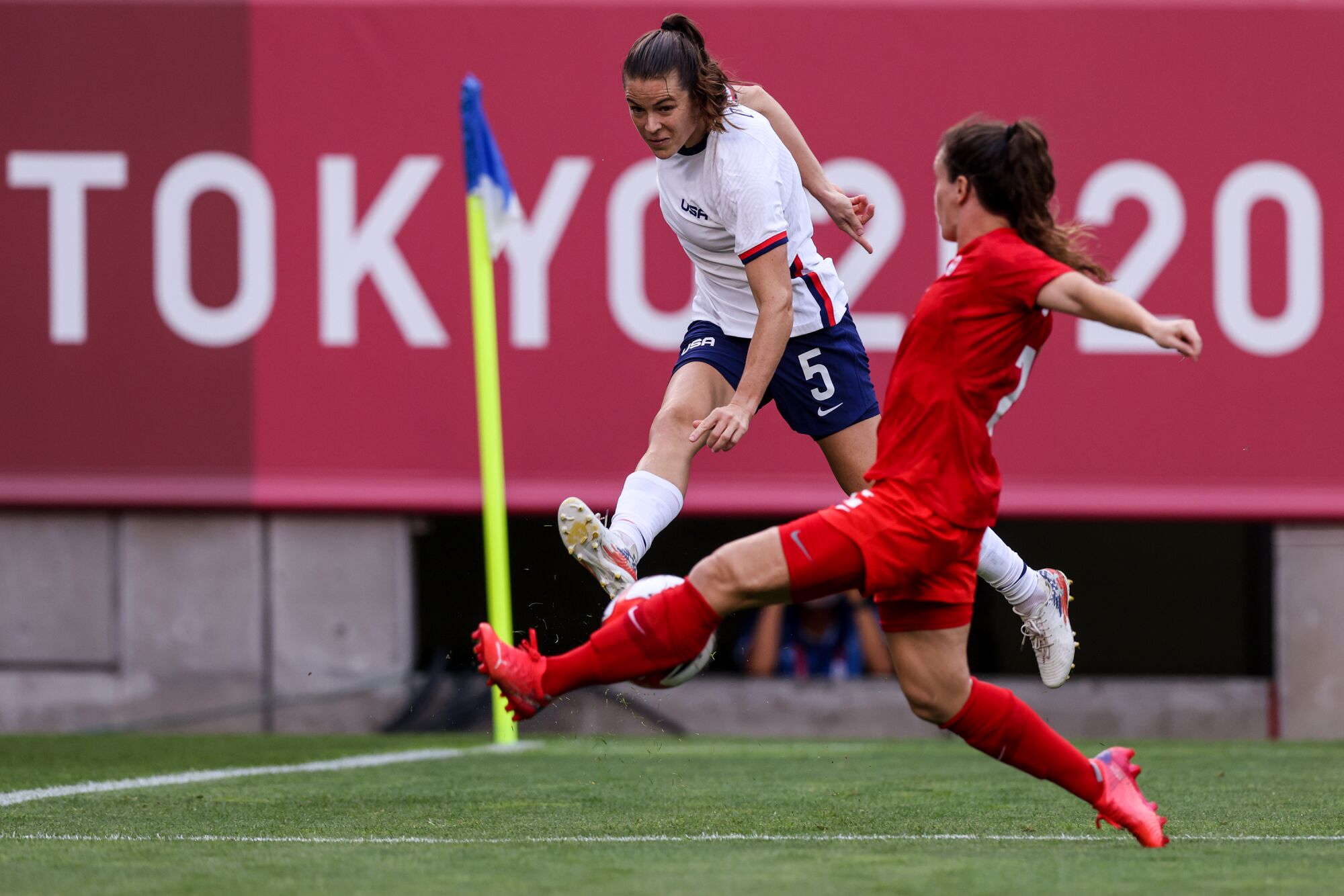 Team USA defender Kelley O'Hara (5) can't shake Team Canada midfielder Julia Grosso (7)