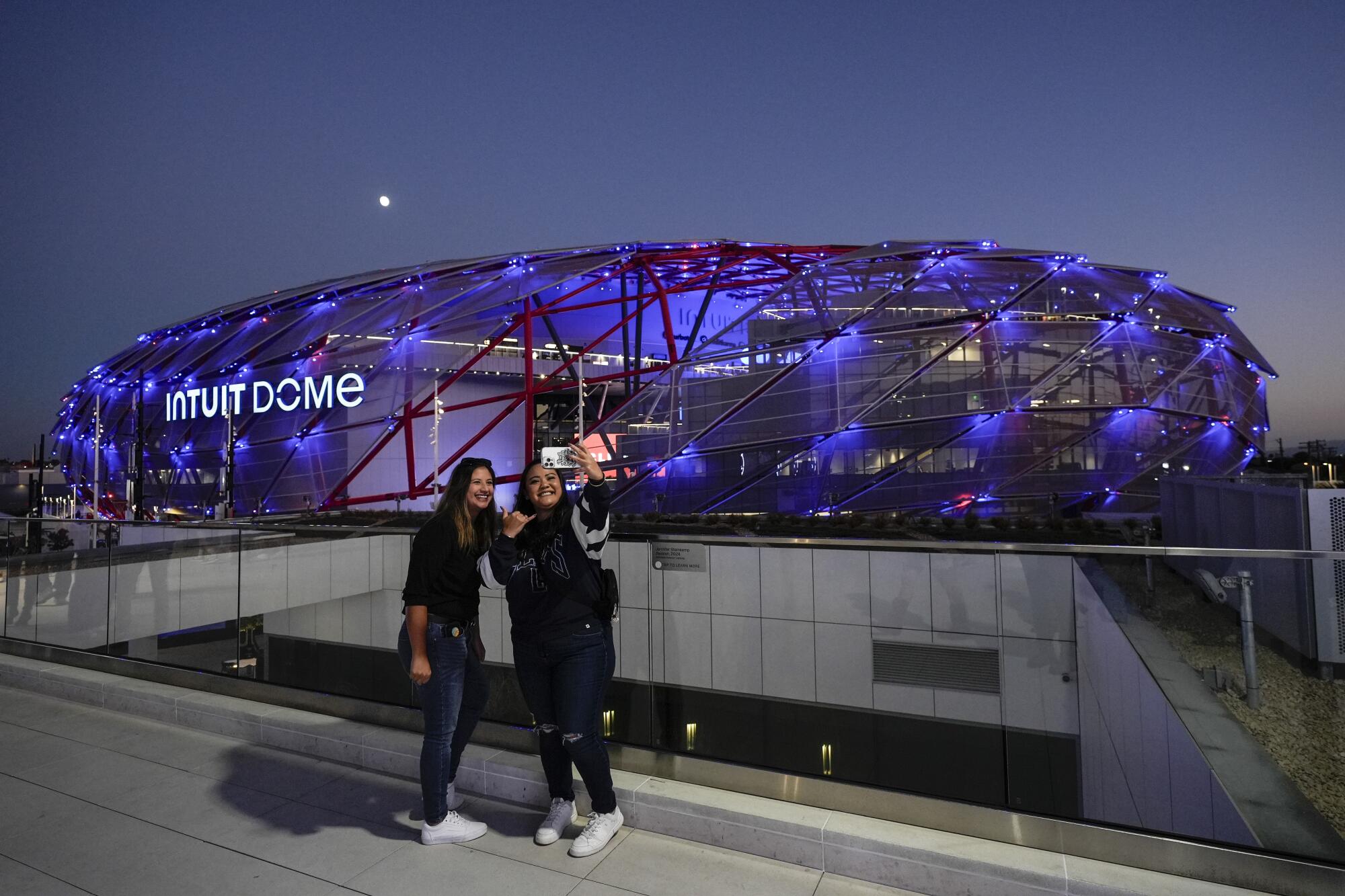 Two fans take a selfie outside the Intuit Dome, the new home of the Clippers, before a preseason game on Oct. 14.