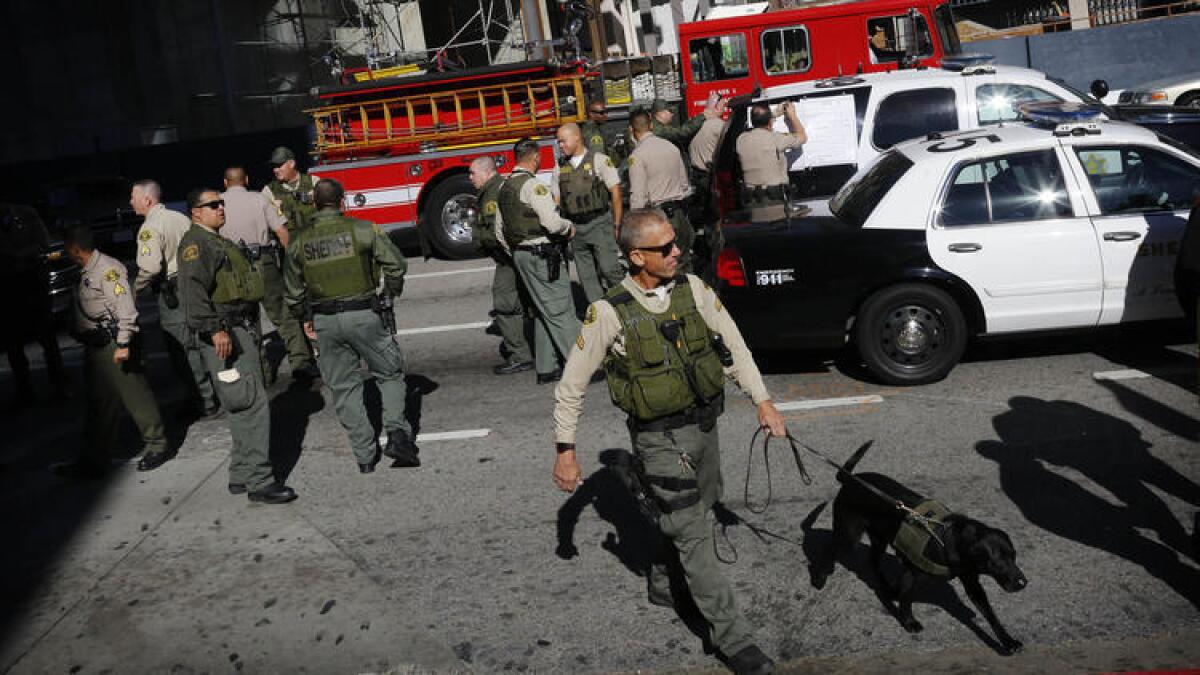 El oficial Rich Faulk trabaja con su perro Clyde, para hacer una revisión en el centro de los Angeles después de que la estación 7th Street/Metro Center fue evacuada cuando la estación se empezó a llenar de humo.
