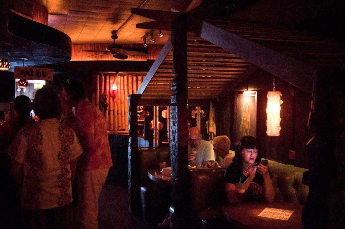 Patrons of Tonga Hut, said to be LA's oldest tiki bar, take refugee in the dark and cool environment on a summer day in North Hollywood.