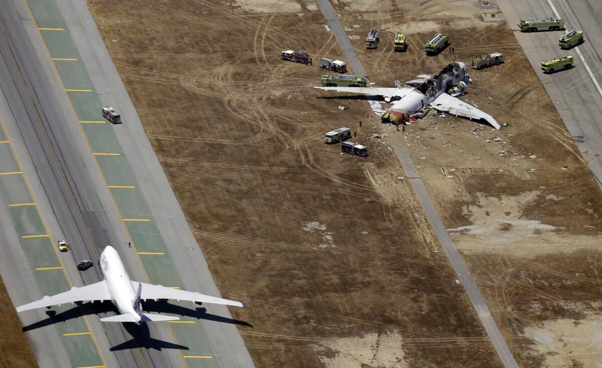 Emergency crews respond at the scene of the wreckage of Asiana Airlines Flight 214