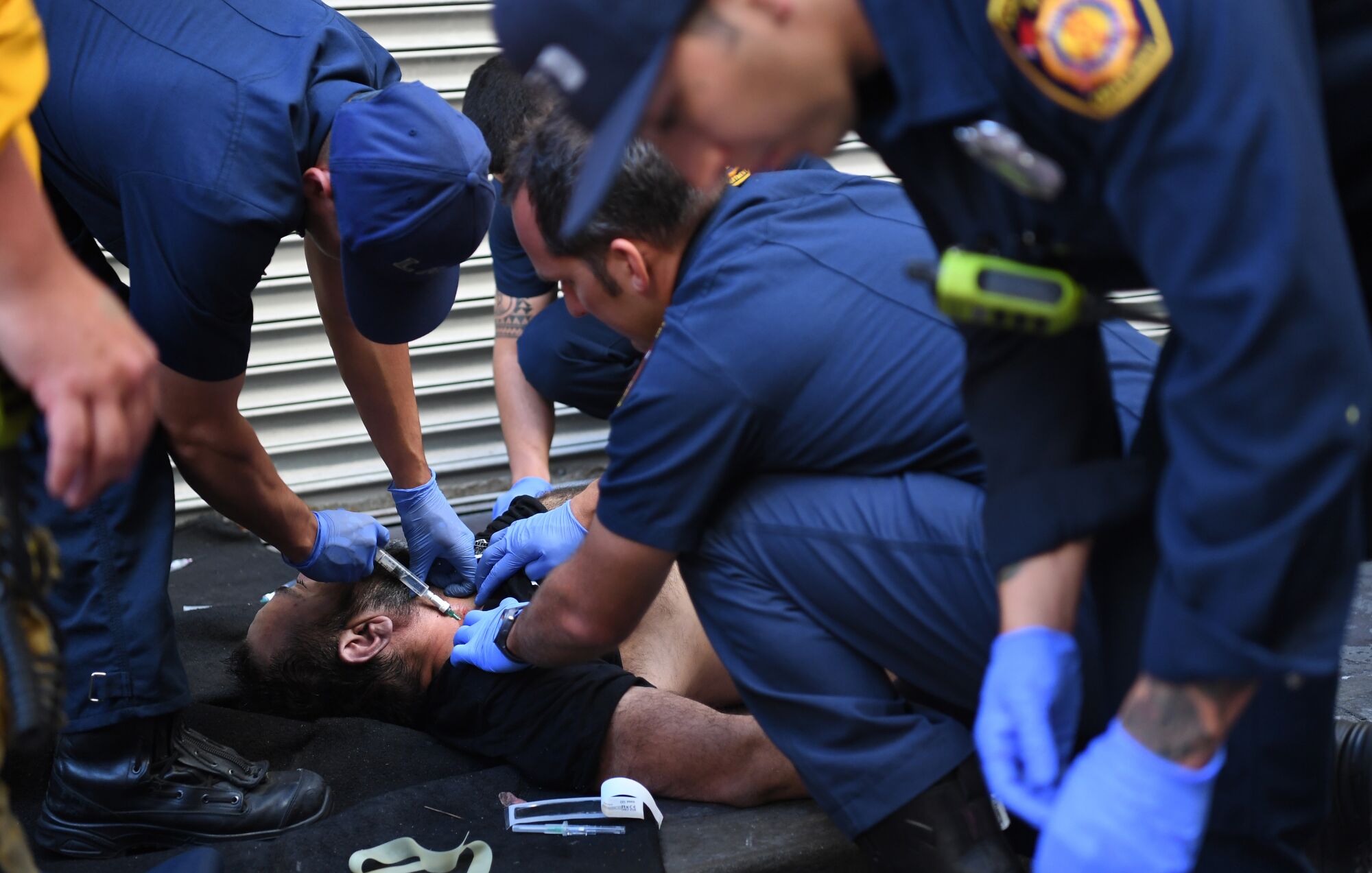 Los Angeles firefighters inject naloxone into the neck of an overdose patient