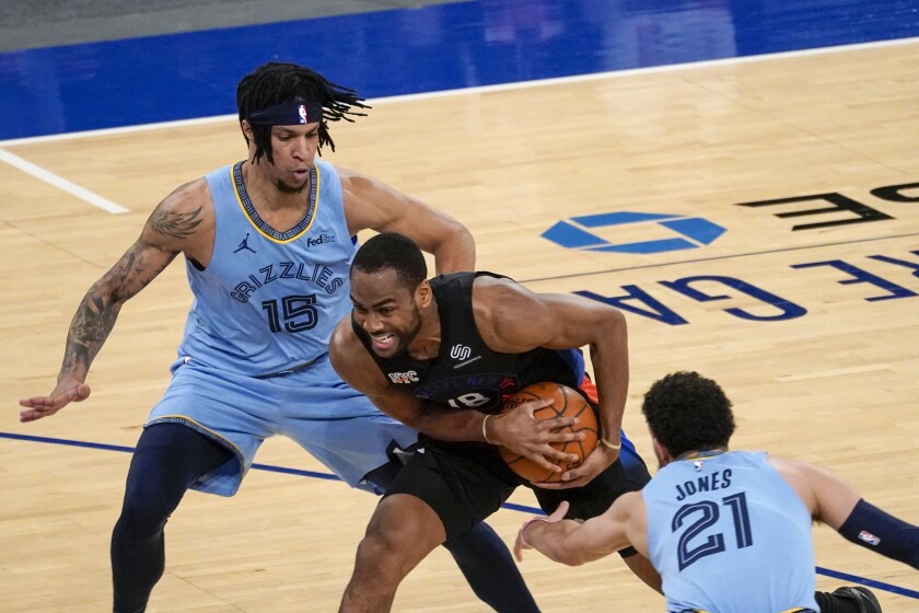 New York Knicks guard Alec Burks (18) drives against Memphis Grizzlies forward Brandon Clarke (15) and guard Tyus Jones (21) during the first half of an NBA basketball game Friday, April 9, 2021, at Madison Square Garden in New York. (AP Photo/Mary Altaffer, Pool)