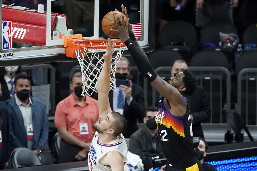 CORRECTS TO SECOND HALF INSTEAD OF FIRST HALF - Phoenix Suns center Deandre Ayton, right, scores over Los Angeles Clippers center Ivica Zubac during the second half of Game 2 of the NBA basketball Western Conference Finals, Tuesday, June 22, 2021, in Phoenix. (AP Photo/Matt York)