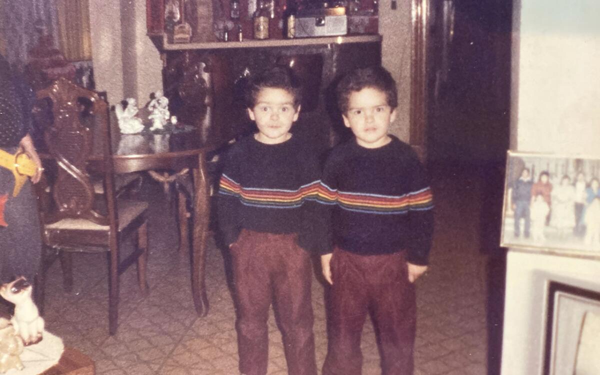 Two twin boys in matching outfits 