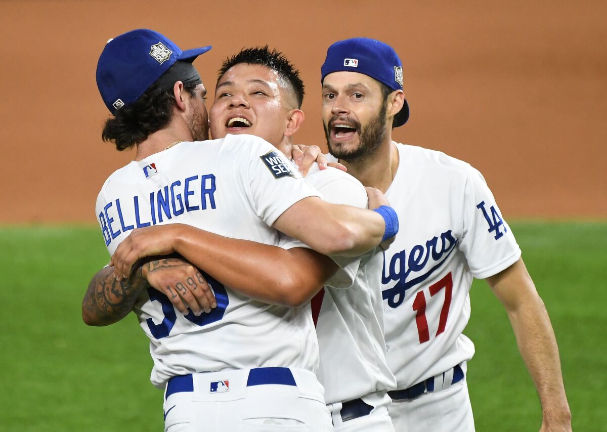 Dodgers pitcher Julio Urías celebrates with Cody Bellinger and Joe Kelly.