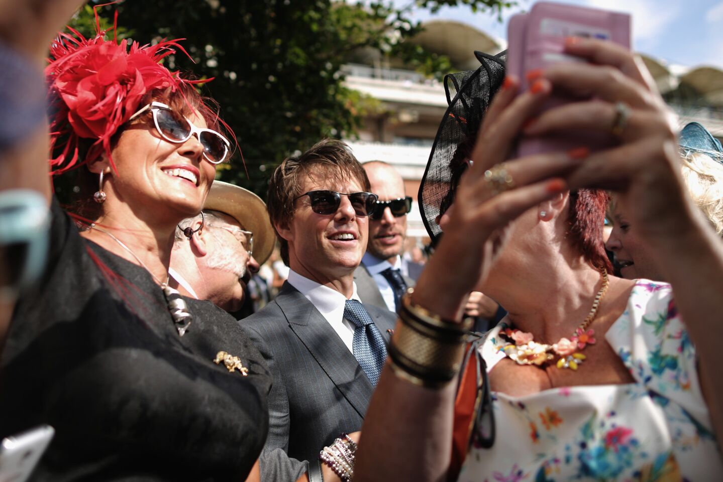 Women take selfies with actor Tom Cruise during Ladies Day at the prestigious Goodwood Races in Chichester, England, on July 31, 2014.